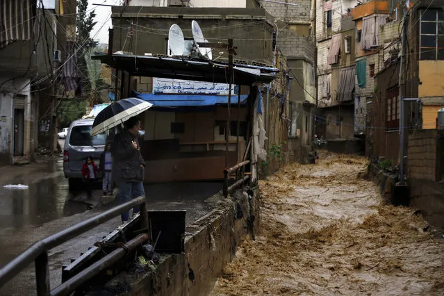 Rushing rainwater fills a canal in Beirut, Lebanon, Tuesday, January 8, 2019. A strong storm and heavy rainfall turned streets in Lebanon into rivers of water and mud and paralyzed parts of the country. The government ordered schools shut with snow expected to fall across the country at altitudes of 600 meters. (Photo by Bilal Hussein/AP Photo)