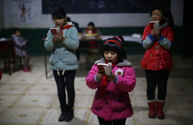 Students read a lecture from Mao Zedong's “Little Red Book” at the Democracy Elementary and Middle School in Sitong town, Henan province December 3, 2013. (Photo by Carlos Barria/Reuters)