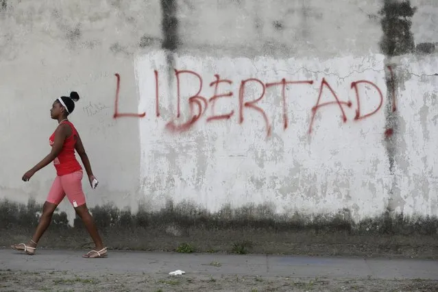 A young woman walks near graffiti that reads “Freedom!” in Havana February 21, 2016. President Barack Obama will meet dissidents and President Raul Castro in Cuba next month, the White House said on Thursday, announcing a historic trip that will be another major step toward ending decades of animosity between former Cold War foes. (Photo by Enrique de la Osa/Reuters)