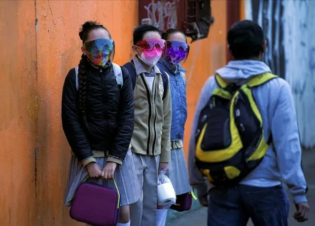 Students wait in line to enter a public school as the new school year begins during the COVID-19 pandemic in Mexico City, Monday, August 30, 2021. School begins for millions of Mexican children Monday, but who sits inside a classroom, who continues studying online from home and who simply doesn't return remains to be seen as a new school year gets underway in the COVID-19 pandemic. (Photo by Fernando Llano/AP Photo)