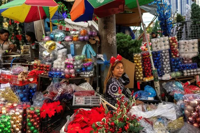 A vendor selling Christmas decorations waits for customers at a street market in Quezon City, Metro Manila, Philippines on November 28, 2023. (Photo by Eloisa Lopez/Reuters)