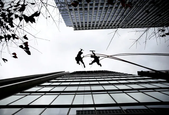 Window cleaners, dressed as a dog (R) and wild boar, this year's and next year's Chinese zodiac animals, pose while cleaning the windows of Ryumeikan hotel during a promotional event to celebrate the upcoming new year in Tokyo, Japan, December 13, 2018. (Photo by Kim Kyung-Hoon/Reuters)