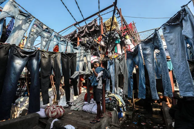 An Indian “Dhobi” (washerman) hangs the washed clothes on a rope for drying at the Mahalaxmi Dhobi Ghat in Mumbai, India, 13 March 2019. The Dhobi Ghat is an open-air laundromat where Indian washermen perform laundering and ironing for local customers. Dhobi Ghat is a very popular attraction among foreign tourists. (Photo by Divyakant Solanki/EPA/EFE)