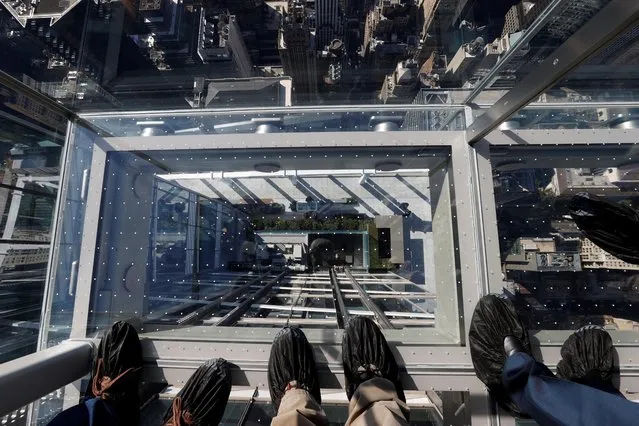 People ride the outdoor glass elevator at the SUMMIT One Vanderbilt observation deck atop the new One Vanderbilt tower in midtown Manhattan in New York City, New York, U.S., October 21, 2021. (Photo by Mike Segar/Reuters)