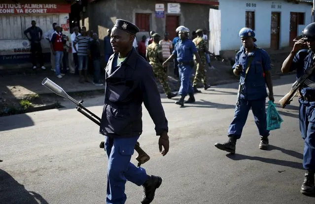 Policemen walk on a street after they cleared barricades set up by protesters in Bujumbura, Burundi, May 10, 2015. (Photo by Goran Tomasevic/Reuters)