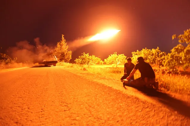 Syrian fighters from the Turkish-backed National Liberation Front (NLF) fire a missile against regime positions on May 13, 2019 in the rebel-held northern part of Syria's Hama province. Clashes on the edge of a jihadist bastion in northwestern Syria have killed at least 42 fighters in 24 hours, a monitor said today, after regime bombardment on the region devastated health services. (Photo by Omar Haj Kadour/AFP Photo)