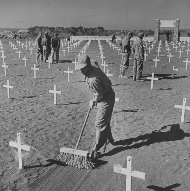 Graves are swept with a broom at an American military cemetery for those killed during the fight for Iwo Jima, 1945. (Photo by W. Eugene Smith/The LIFE Picture Collection/Getty Images)