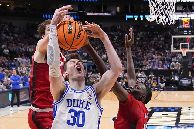 Duke's Kyle Filipowski (30) is blocked by North Carolina State's Ben Middlebrooks, left, and Mohamed Diarra during the first half of an Elite Eight college basketball game in the NCAA Tournament in Dallas, Sunday, March 31, 2024. (Photo by Julio Cortez/AP Photo)
