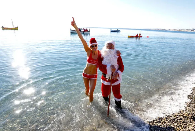 A man dressed as Santa Claus poses with a swimmer during the traditional Christmas bath on the beach of the Promenade des Anglais in Nice, France, December 19, 2021. (Photo by Eric Gaillard/Reuters)