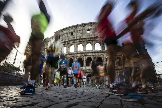Participants run in front of the landmark Colosseum ruin as they attend the Rome Marathon, in the centre of Rome, Italy, April 20, 2016. A total of 16,764 athletes and running enthusiasts have signed in to take part in the 22nd edition of the 'Maratona di Roma', the organizing Italia Marathon Club said in a media release. (Photo by Angelo Carconi/EPA)