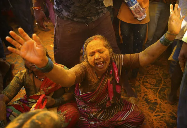 In this Monday, June 3, 2019, photo, a devotee covered in turmeric goes into a trance during the celebration of the Bhandara Festival, or the Festival of Turmeric, at the Jejuri temple in Pune district, Maharashtra state, India. During the festival, devotees use the golden powder to worship the deity Lord Khandoba, widely known as a descendant of the sun, and to celebrate his victory over the demons Mani and Malla. (Photo by Rafiq Maqbool/AP Photo)