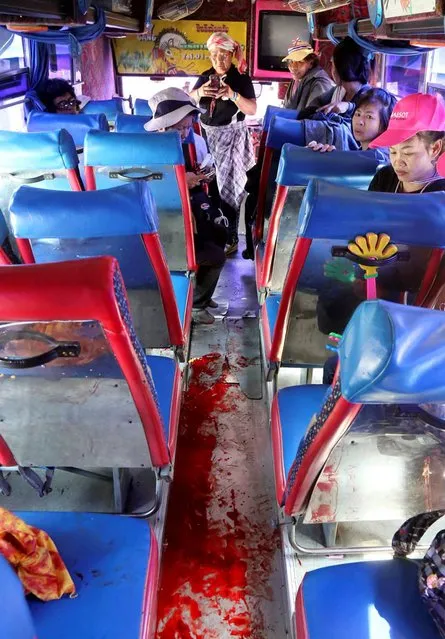 Anti-government protesters look at bloodstained floor of the bus they were traveling after an attack by suspected gunmen while on their way back from a protest in Bangkok, Thailand Tuesday, April 1, 2014. Gunmen have fired on a convoy of anti-government protesters in Thailand's capital, and four people have been wounded. (Photo by AP Photo)