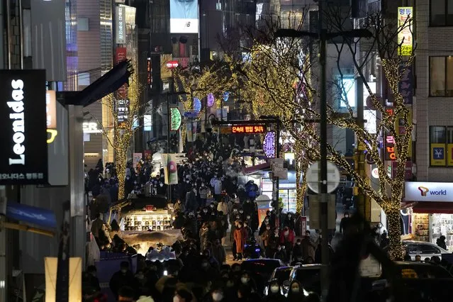 People visit a shopping street on the Eve of Christmas in Seoul, South Korea, Friday, December 24, 2021. (Photo by Ahn Young-joon/AP Photo)