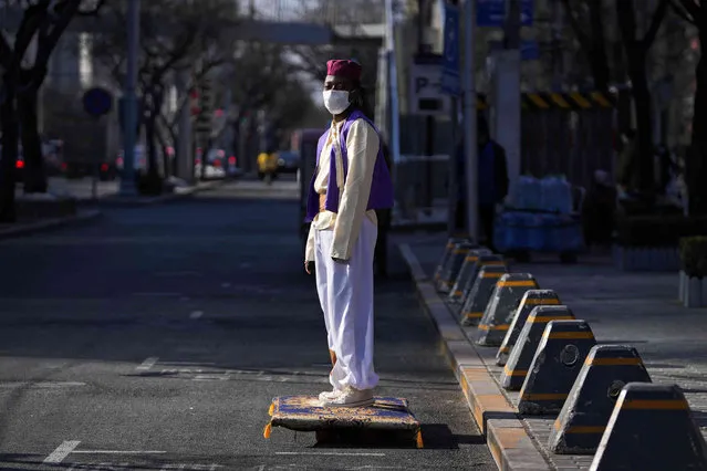 A foreigner dressed in costume as Aladdin, the fictional character from a Middle Eastern folk tale, wears a face mask to help protect from the coronavirus as he rides on a carpet-shaped skateboard in Beijing, Tuesday, January 25, 2022. (Photo by Andy Wong/AP Photo)
