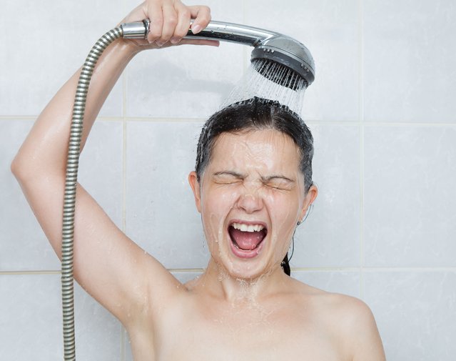 Portrait of a young woman in bathroom screaming in shower. (Photo by Andrey Popov/Getty Images/iStockphoto)