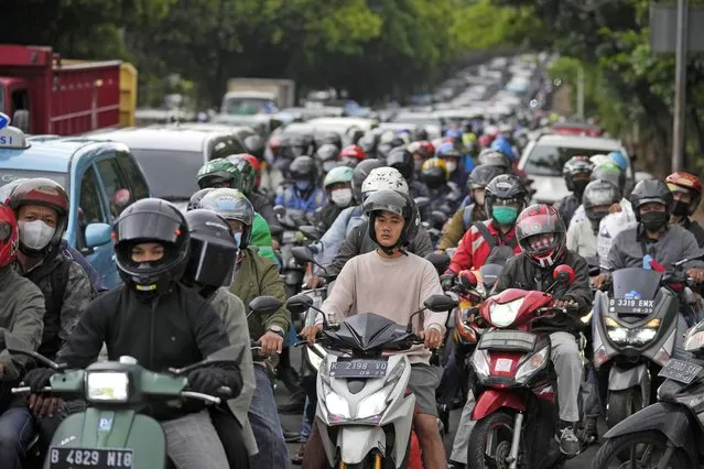 Motorists are stuck in the morning rush hour traffic in Jakarta, Indonesia, Wednesday, January 26, 2022. Indonesian parliament last week passed the state capital bill into law, giving green light to President Joko Widodo to start a $34 billion construction project this year to move the country's capital from the traffic-clogged, polluted and rapidly sinking Jakarta on the main island of Java to jungle-clad Borneo island amid public skepticism. (Photo by Dita Alangkara/AP Photo)