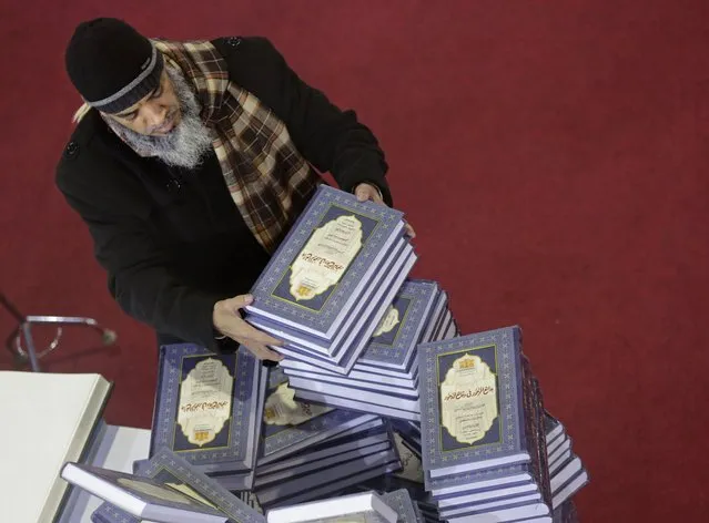 A man selects a series of religious books at the annual Cairo International Book Fair, in Cairo, Egypt, Thursday, January 27, 2022. Publishers from 51 countries participate in the 53rd edition of the Cairo International Book Fair from January 26 to February 7, General Egyptian Book Organization said. (Photo by Amr Nabil/AP Photo)