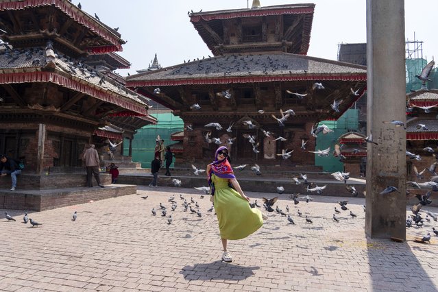 A tourist poses for a photo at Basantapur Durbar Square in Kathmandu, Nepal, Sunday, April 28, 2024. (Photo by Niranjan Shrestha/AP Photo)