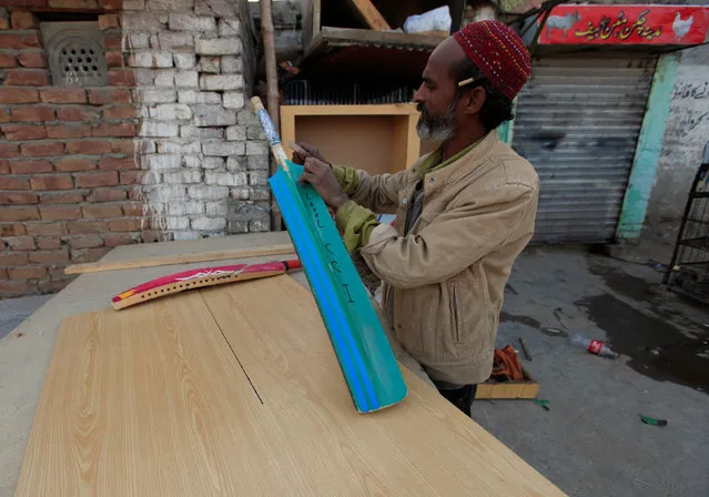 A carpenter repairs a cricket bat at his workshop in Islamabad, Pakistan, February 22, 2017. (Photo by Faisal Mahmood/Reuters)