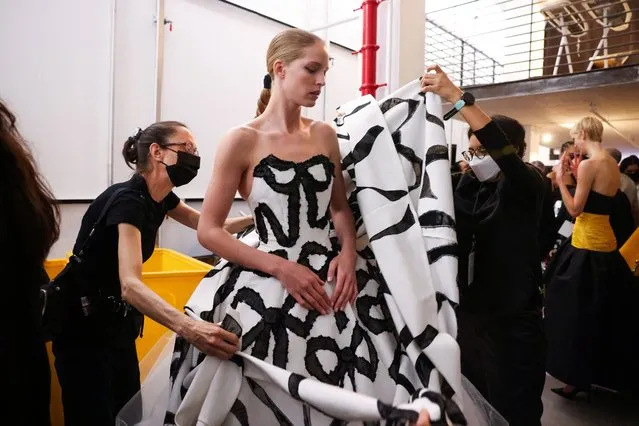 Stylists adjust a model's outfit backstage before the Carolina Herrera show during Fashion Week in New York City, New York, U.S., February 14, 2022. (Photo by Caitlin Ochs/Reuters)