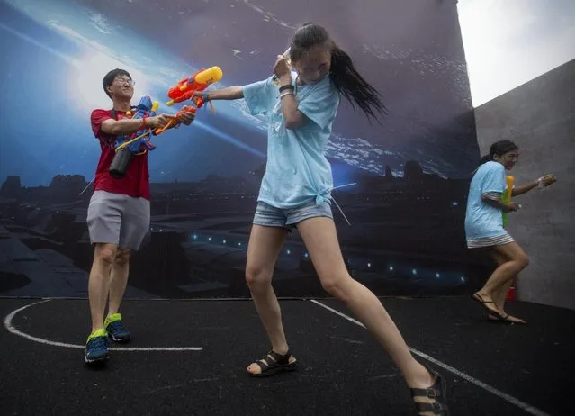 Players fire their water guns in a battle maze in Beijing, Saturday, July 4, 2015. (Photo by Mark Schiefelbein/AP Photo)