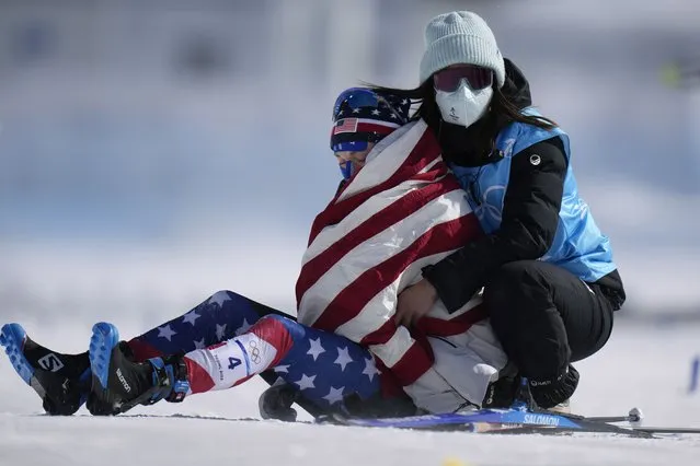 Jessie Diggins is comforted after crossing the finish during the women's 30km mass start free cross-country skiing competition at the 2022 Winter Olympics, Sunday, February 20, 2022, in Zhangjiakou, China. (Photo by Alessandra Tarantino/AP Photo)