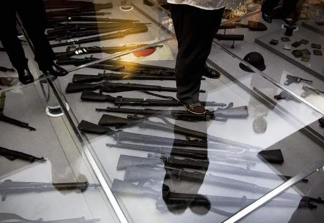 Visitors to the Museum of the War of Chinese People's Resistance Against Japanese Aggression look at the weapons used by the Japanese army during World War II, in Beijing Tuesday, July 7, 2015. Soldiers and children stood in silence outside the museum in suburban Beijing at the opening ceremony for the “Great Victory and Historical Contribution” exhibition on the 78th anniversary of the Marco Polo Bridge Incident. (Photo by Andy Wong/AP Photo)