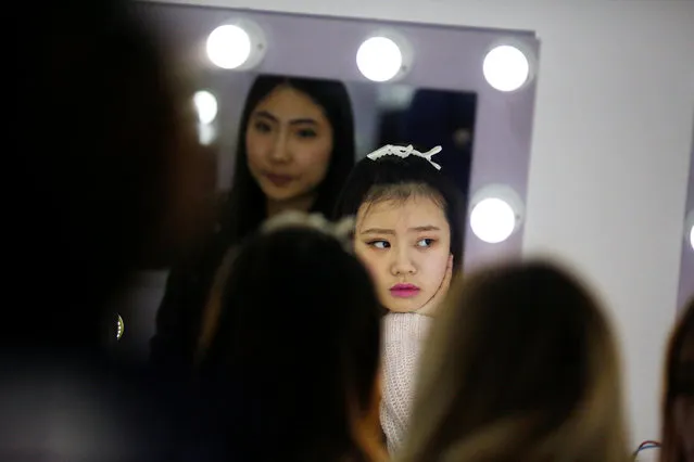 Girls attend make-up training session at live streaming talent agency Three Minute TV in Beijing, China on April 12, 2017. The fastest-emerging internet sector barely existed in China three years ago but last year produced revenues of more than 30 billion yuan ($4.3 billion) and according to an estimate by investment bank China Renaissance Securities, is set to more than triple that by 2020. That puts it on track to overtake cinema box office receipts in a few year’s time. The rapid growth of live streaming in China has attracted a rush of investment, led by China’s tech heavyweights, Tencent Holdings, Alibaba Group Holding and Baidu Inc. They hope live streaming can boost existing services in e-commerce, social networking and gaming. Tencent, the country’s biggest online gaming and social networking company, is backing a slew of streaming and interactive entertainment firms, including gaming platform Douyu. Alibaba's Taobao marketplace launched a live-streaming platform early last year, allowing sellers to promote products directly to online viewers in real time. The lure is some 344 million Chinese netizens – more than the population of every country on the planet bar China and India – who were watching live streaming sites in December. And that is only about 47 percent of all Chinese Internet users. There are about 150 live streaming platforms, most producing entertainment shows. The importance of live streaming in lower-tier cities is greater than elsewhere in China. Access to the internet via a mobile phone is the major, if not the only, gateway to shopping and entertainment, said Karen Chan, equities analyst at Jefferies Hong Kong. Live streaming has also bolstered the growth of ancillary businesses, including agencies looking to find the next live streaming star, consumer loans, and even cosmetic surgery. Deng Jian, chairman of Three Minute TV, an agency that provides 1,000 trained anchors to more than three dozen platforms, said his business operates a “militarized” production machine to feed the live streaming industry. At an office building in a suburb of Beijing, dozens of Deng’s female anchors work each day around the clock in three shifts. Each anchor sits in a small booth, decorated to appear like a girl’s bedroom, facing a computer. They sing and flirt with fans, encouraging them to buy virtual gifts, like a rose, sportscar or villa. The cash for the gifts is split by the platforms, agencies and the anchor. Three Minute TV also arranges cosmetic surgery at partner hospitals for its anchors, arranges small bank loans for the surgery, photographs and markets the anchors and helps them find acting opportunities Deng said. In July, China's culture ministry announced that it had shut down 4,313 online show rooms, firing or punishing more than 18,000 anchors. Twelve platforms, including heavyweights Panda TV, 6.CN and Douyu, were punished and ordered to make changes after offering illicit content that “promotes obscenity, violence, abets crime and damages social morality”. Still, the prospect of change in the sector hasn’t faded the hopes of thousands of young Chinese who want to become internet stars. (Photo by Thomas Peter/Reuters)