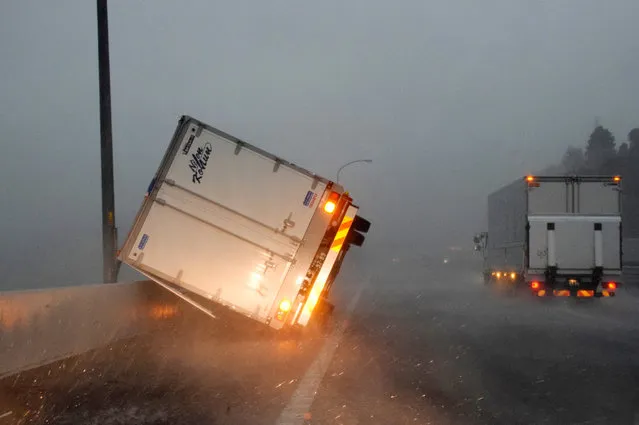A truck lies on its side due to strong wind generated by Typhoon Faxai on a highway in Tomisato, Chiba prefecture, near Tokyo, Japan, 09 September 2019. Typhoon Faxai landed near Tokyo overnight, affecting commuters from the early morning on due to suspended train and airlines services. According to latest media reports, 20 people were injured as a result of the storm. (Photo by JIJI Press/EPA/EFE)