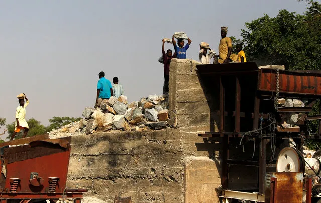 People carry rocks to tip into a granite crushing machine in Zamfara, Nigeria, April 21, 2016. (Photo by Afolabi Sotunde/Reuters)