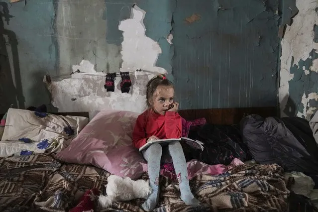A girl sits in the improvised bomb shelter in Mariupol, Ukraine, Monday, March 7, 2022. (Photo by Evgeniy Maloletka/AP Photo)