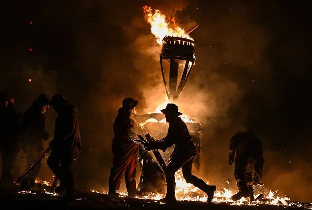The Clavie, a burning barrel packed with tar soaked sticks fixed on the top of a pole, is surrounded by Clavie Crew at the Doorie Hill on January 17, 2022 in Burghead, Scotland. The centuries-old local tradition is usually held on January 11 to greet the New Year, but was rescheduled until after pandemic-inspired restrictions on large outdoor events were lifted by the Scottish Government. (Photo by Jeff J. Mitchell/Getty Images)