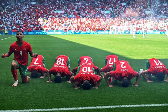 Morocco's forward #09 Soufiane Rahimi (L) kneels as he celebrates after scoring his team's first goal, as his teammates touch their forehead to the ground in the men's group B football match between Argentina and Morocco during the Paris 2024 Olympic Games at the Geoffroy-Guichard Stadium in Saint-Etienne on July 24, 2024. (Photo by Arnaud Finistre/AFP Photo)