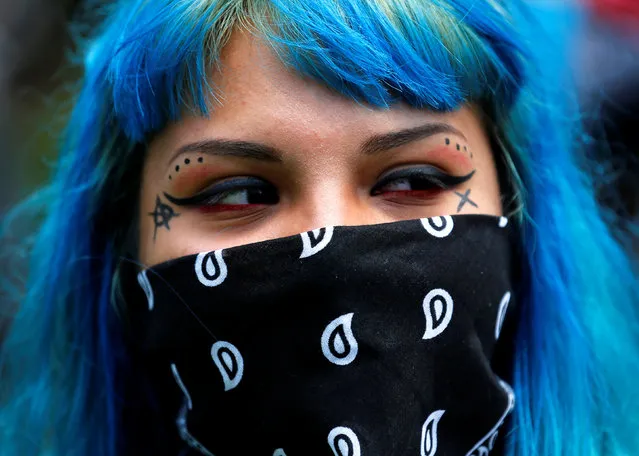 A demonstrator hides part of her face as she protests near the convention center where U.S. Republican presidential candidate Donald Trump held a campaign rally in Anaheim, California, United States May 25, 2016. (Photo by Mike Blake/Reuters)