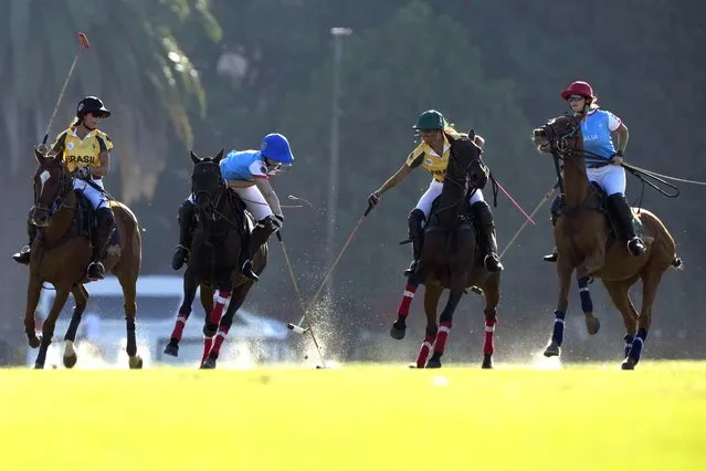 Italy's Maria Vittoria Marchiorello, center left, and Brazil's Eduarda Vilela fight for the ball during a match at the Women's Polo World Championship in Buenos Aires, Argentina, Saturday, April 9, 2022. (Photo by atacha Pisarenko/AP Photo)
