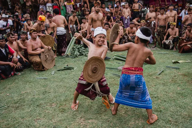 Balinese fighters fight as they are armed with thorny pandanus leafs during an annual sacred Usaba Sambah ritual in Tenganan, Karangasem, Bali, Indonesia, 12 June 2017. Through the duels, the fighters believe they have made a sacrification for the gods to balance the human body and the universe. (Photo by Made Nagi/EPA)