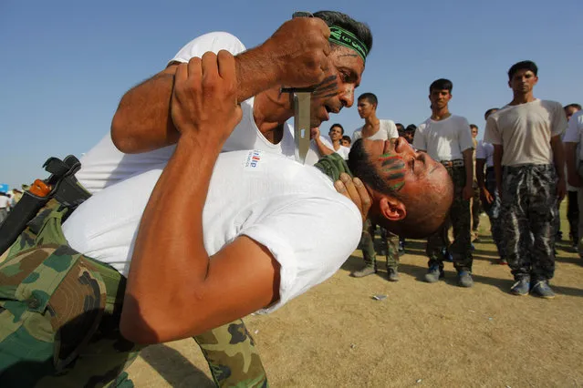 Shiite volunteers, who have joined the Iraqi army to fight against the predominantly Sunni militants from the radical Islamic State of Iraq and the Levant (ISIL), demonstrate their skills during a graduation ceremony after completing their field training in Najaf, June 27, 2014. (Photo by Alaa Al-Marjani/Reuters)