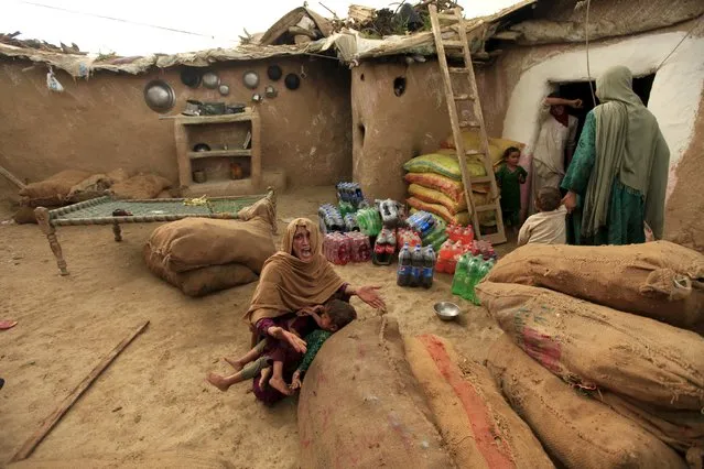 A resident of an illegal settlement protest the destruction of their homes by the officials and police on the outskirts of Islamabad July 30, 2015. According to local media, clashes broke out in Islamabad between authorities and residents of a slum on Thursday as authorities started bulldozing illegal settlements in the area. (Photo by Faisal Mahmood/Reuters)