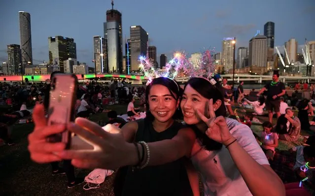 Mizuki (L) and Tsubasa take a selfie as they wait to watch the New Year's Eve fireworks at Southbank in Brisbane, Australia, 31 December 2019. (Photo by Dan Peled/EPA/EFE/Rex Features/Shutterstock)