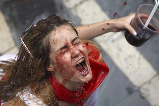 A reveller catches wine thrown from a balcony during the opening day or “Chupinazo” of the San Fermin Running of the Bulls fiesta on July 6, 2017 in Pamplona, Spain. The annual Fiesta de San Fermin, made famous by the 1926 novel of US writer Ernest Hemmingway entitled “The Sun Also Rises”, involves the daily running of the bulls through the historic heart of Pamplona to the bull ring. (Photo by Pablo Blazquez Dominguez/Getty Images)