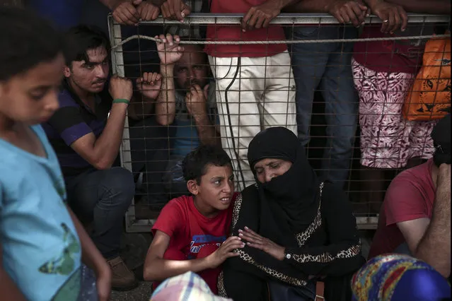 Migrants wait for a registration procedure outside a police station at southeastern island of Kos, Monday, August 10, 2015. (Photo by Yorgos Karahalis/AP Photo)