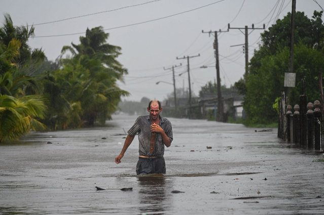 A residents of the coastal town of Guanimar in Artemisa province, southwest of Havana, wade trough a flooded street after the passage of Hurricane Helene on September 25, 2024. Tropical Storm Helene became a hurricane mid-morning in the Gulf of Mexico. “Life-threatening storm surge, hurricane-force winds, rainfall and flooding are expected across much of Florida and the southeastern United States”, the Miami-based National Hurricane Center (NHC) said in its latest bulletin. (Photo by Yamil Lage/AFP Photo)