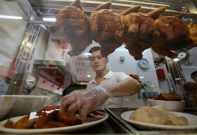 Hawker Derrick Lee, 30, sells chicken rice in his stall at a hawker centre in Singapore June 30, 2016. (Photo by Edgar Su/Reuters)
