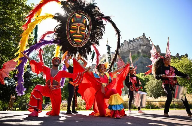 Methetheli from Capetown poses with dancers Marquise and Okia from Port Spain Trinidad pose during a photo call at Ross Fountain, Princes Street Gardens on July 07, 2022 in Edinburgh, Scotland. Scotland's largest multicultural celebration returns to the streets of Edinburgh on July 17, featuring a host of international and Scottish artists including musicians, dancers, poets and acrobats. (Photo by Jeff J. Mitchell/Getty Images)