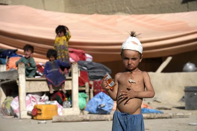 Injred boy stands in front of a makeshift shelter after an earthquake in Gayan village, in Paktika province, Afghanistan, Friday June 24, 2022. A powerful earthquake struck a rugged, mountainous region of eastern Afghanistan early Wednesday, flattening stone and mud-brick homes in the country's deadliest quake in two decades, the state-run news agency reported. (Photo by Ebrahim Nooroozi/AP Photo)