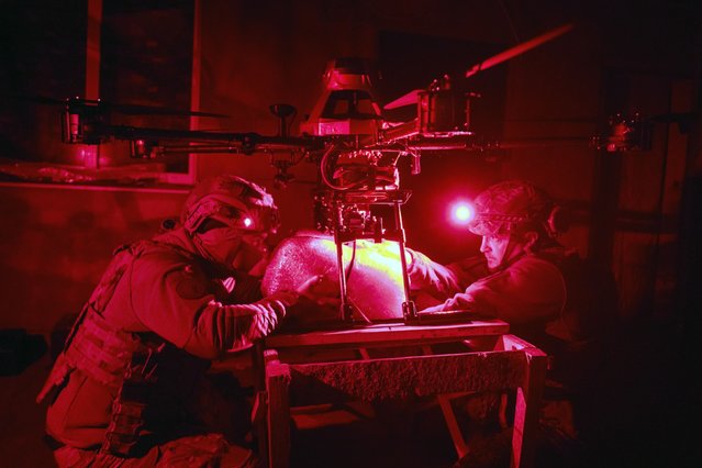 Servicemen of 13th Brigade of the National Guard of Ukraine attach a food package to a “Vampire” drone for delivery to Ukrainian positions on the front line near Kharkiv, Ukraine, late Thursday, November 7, 2024. (Photo by Efrem Lukatsky/AP Photo)