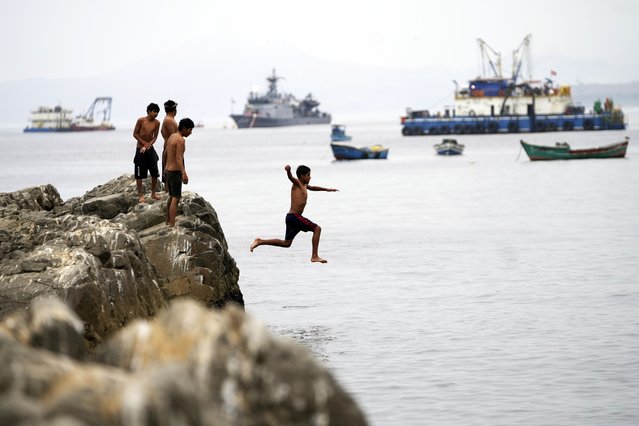 A youth jumps into the water near a Chinese-funded port in Chancay, Peru, Tuesday, November 12, 2024. (Photo by Silvia Izquierdo/AP Photo)