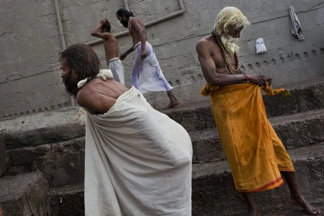 Hindu devotees dress after taking a bath in the Godavari River during Kumbh Mela, or Pitcher Festival, in Nasik, India, Saturday, August 29, 2015. (Photo by Bernat Armangue/AP Photo)