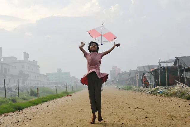 A girl flies a kite in the afternoon in Dhaka, Bangladesh on August 3, 2022. (Photo by Mohammad Ponir Hossain/Reuters)