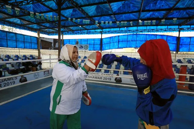 Shahnaz Kamal Khan (L) coaches a student during a training session at the stadium in Peshawar, Pakistan December 20, 2019. Kamal is the first and only international female boxing coach registered with the boxing federation of Pakistan, in a male-dominated sport and a conservative country. That hasn't stopped the Peshawar-born woman from making her mark – she's doing her best to nurture a younger generation of boxers. (Photo by Fayaz Aziz/Reuters)